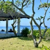 Thatched-roof beach gazebo at Luxor Resort with view of the Tres Reyes Islands
