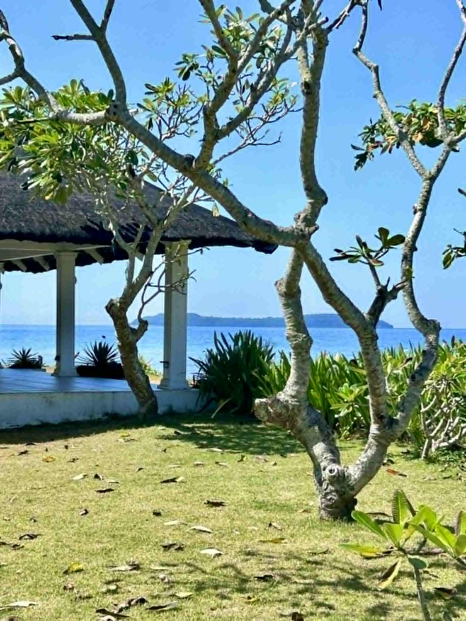 Thatched-roof beach gazebo at Luxor Resort with view of the Tres Reyes Islands